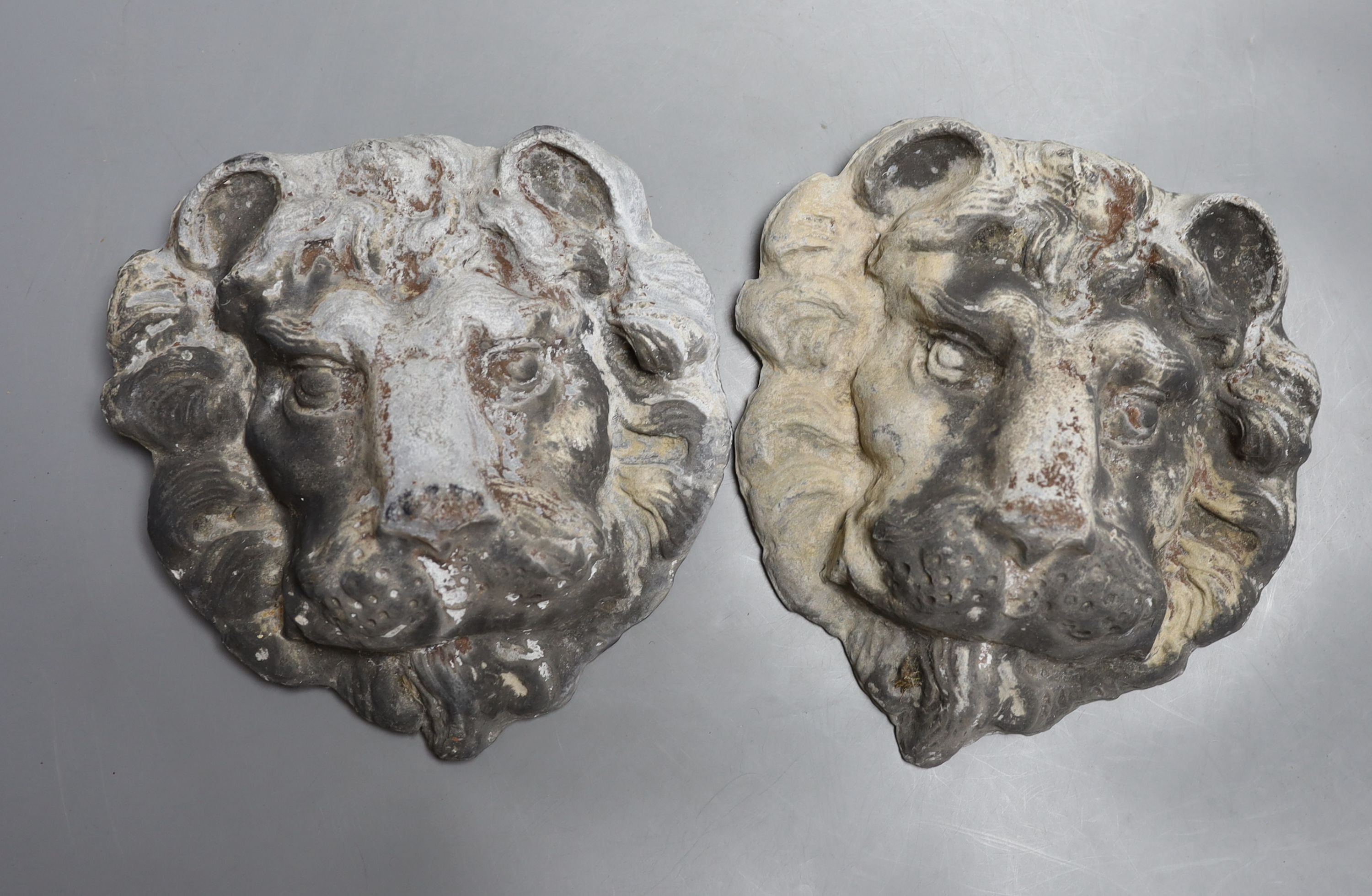 A pair of lead lion masks - 22cm tall